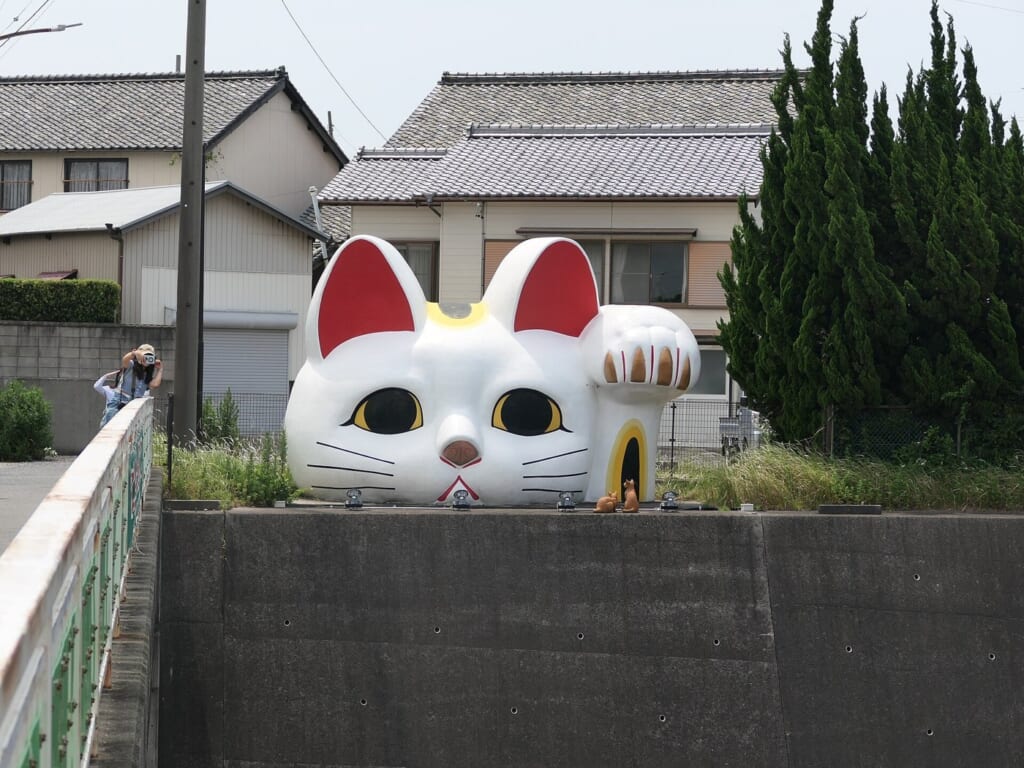 常滑の丘から顔を出す巨大招き猫とこにゃん